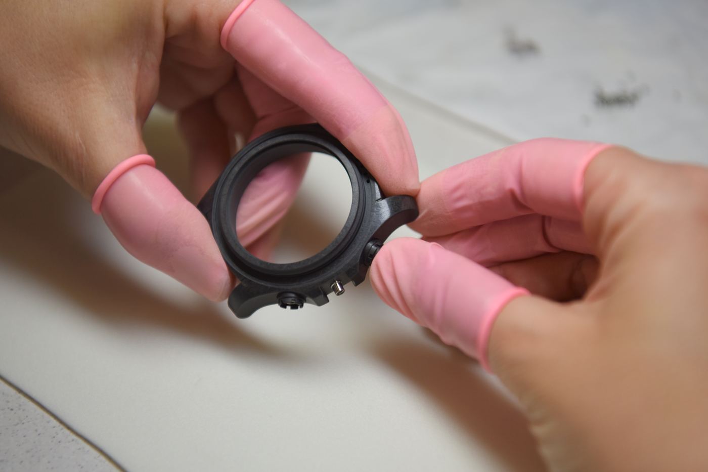 Boîte de montre assemblée, tenue entre les doigts